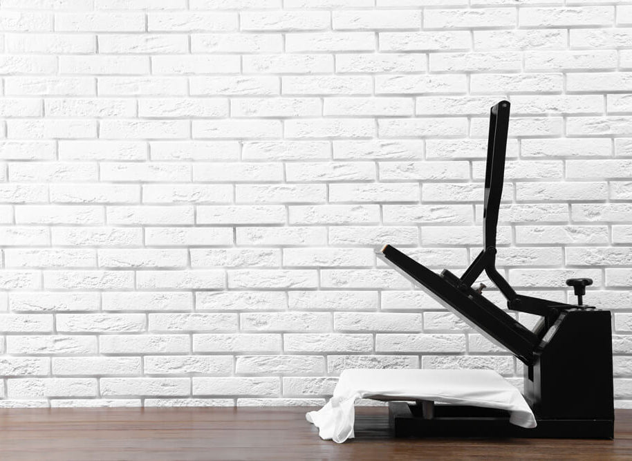 Heat press in the open position with a white t-shirt, on a timber desk.
